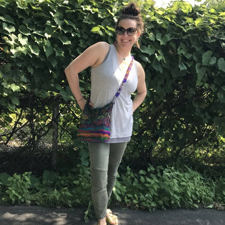 A woman outside with a multicolored cross body purse on