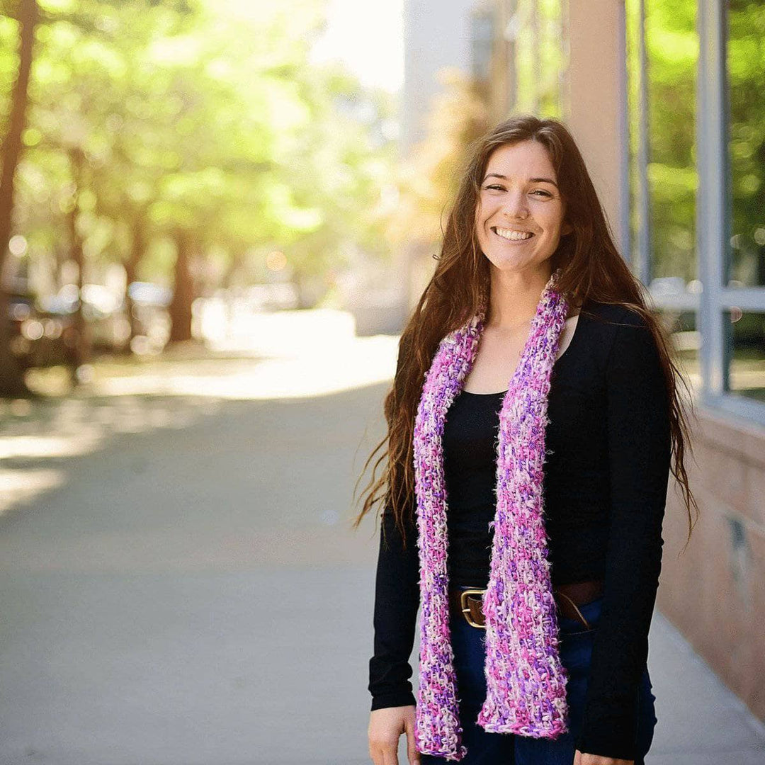 woman wearing a Simple Tunisian Crochet Scarf and smiling outdoors