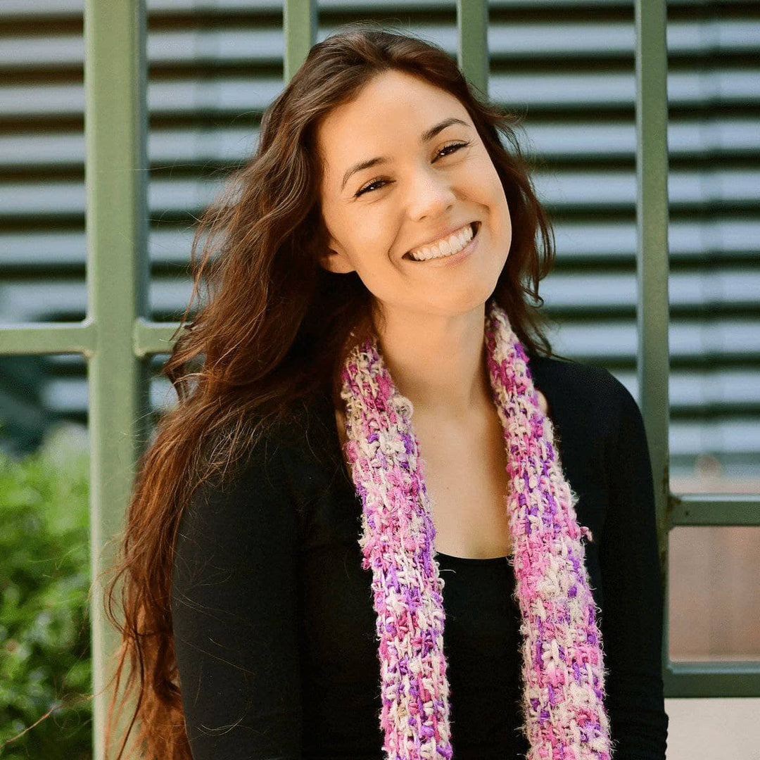 woman wearing a Simple Tunisian Crochet Scarf and smiling outdoors