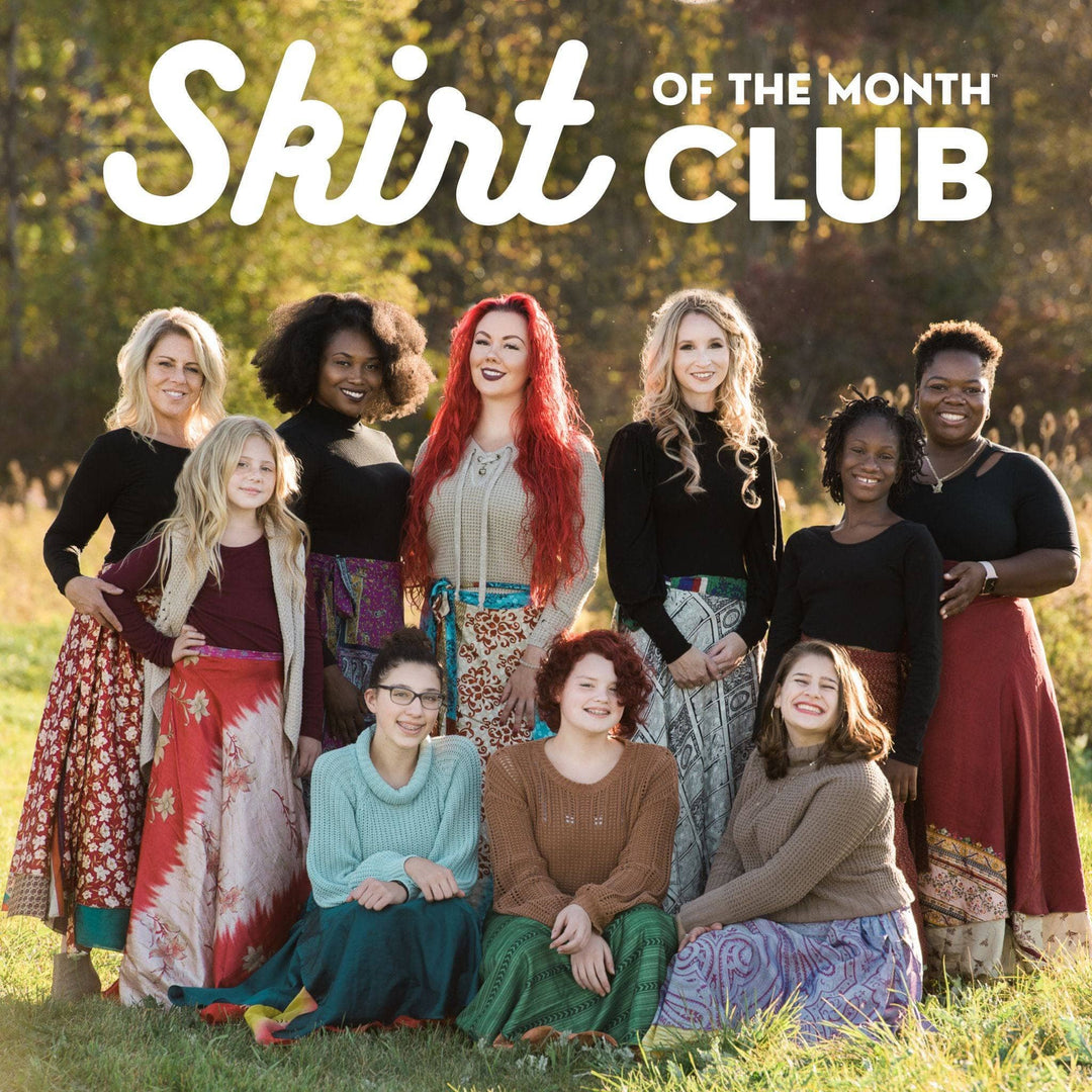 A Group of women standing in a field wearing wrap skirts made from reclaimed sari silk materials.