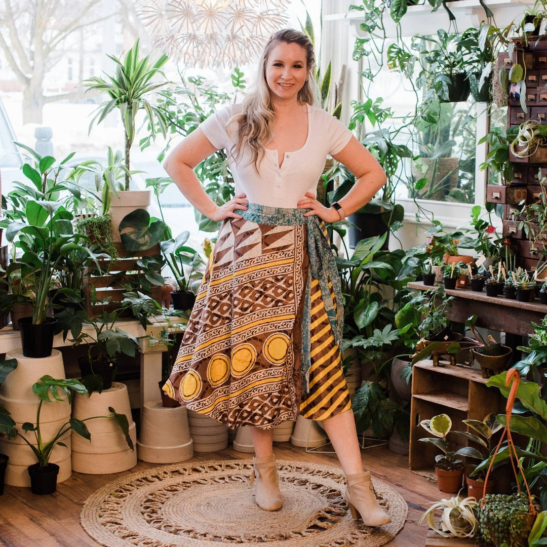 A woman confidently showcasing her wrap skirt with plans in the background.