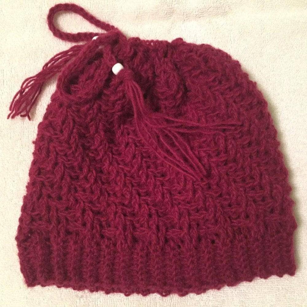 completed spiral hat in red in front of a beige background.