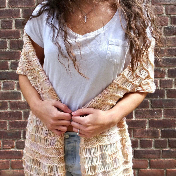 Woman wearing the Spring Vibes Shawl in Samabyon against a brick wall