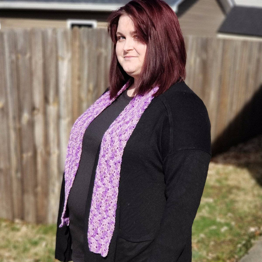 Woman wearing the Springy Shells Silk Scarf in front of a wooden fence