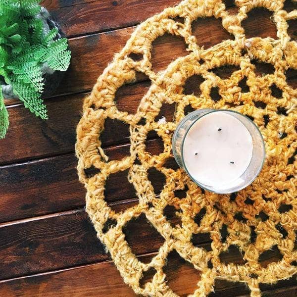 Sunshine Mat in Sunflower (yellow) on a wooden table with a white candle