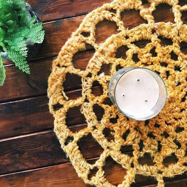 Sunshine Mat in Sunflower (yellow) on a wooden table with a white candle