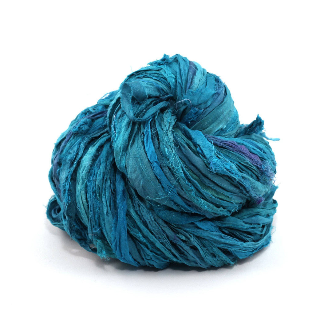 Sari Silk Ribbon Yarn ball in Teals Galore on a white background