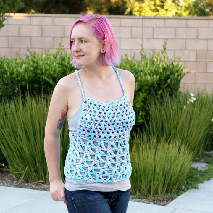 Woman with pink hair wearing The Celia Tank Top in front of a children's playground