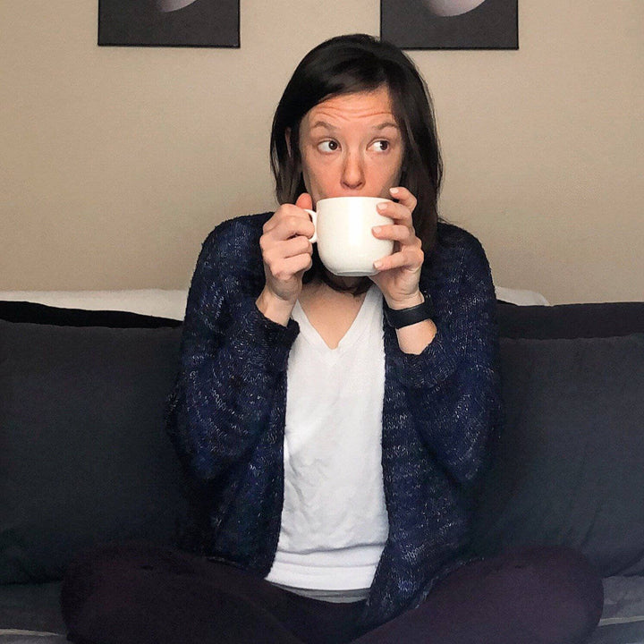 a person wearing a purple cardigan sitting down