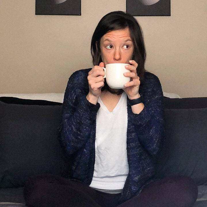 a person wearing a purple cardigan sitting down