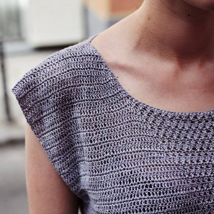 Woman wearing the Crossed Stitched Top in Gray against a white background