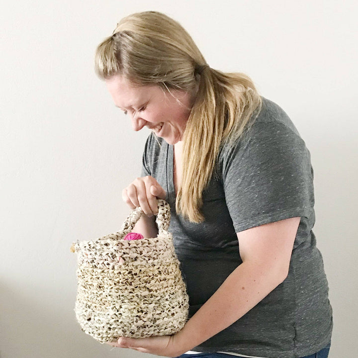 The Hayden Hanging Basket holding balls of yarn held by a woman in a gray shirt on a white backdrop