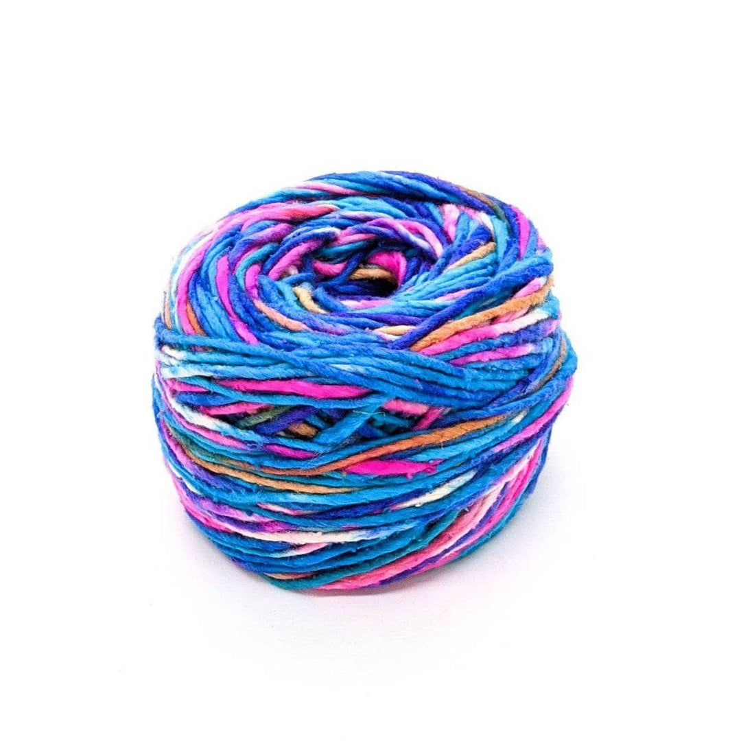 A cake of blue, pink, white, tan, and purple yarn on a white background