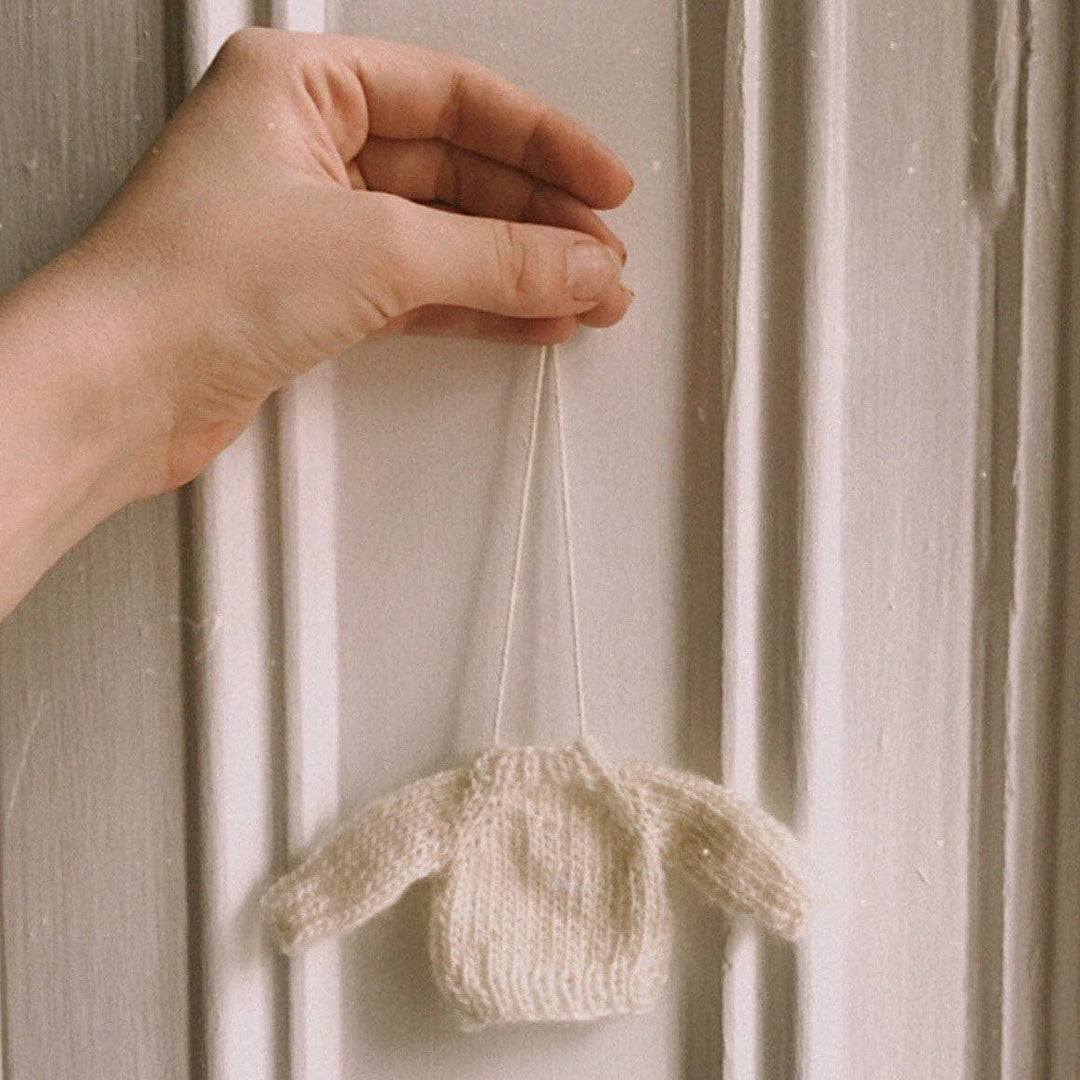 tiny white sweater ornament on a white background