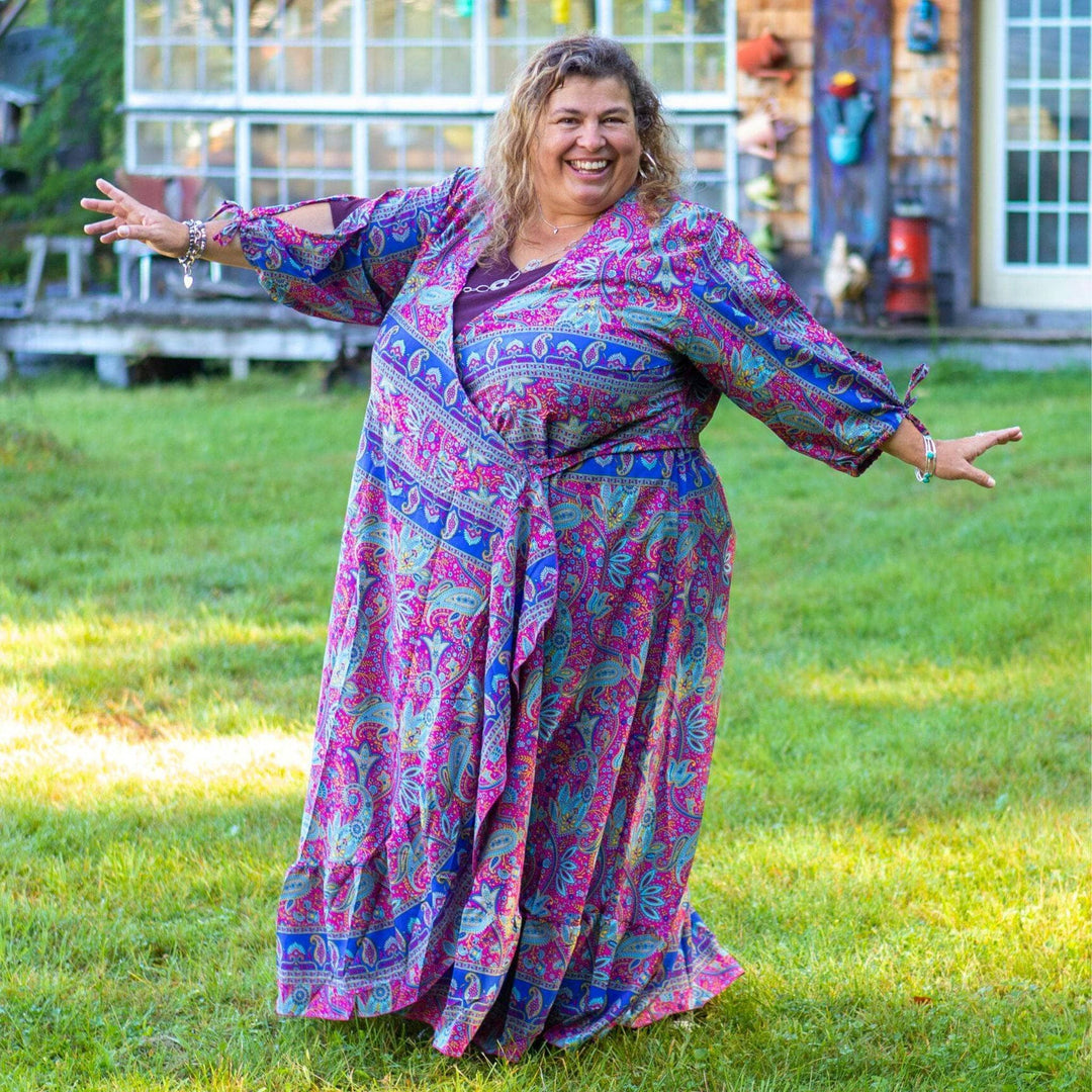 A woman happily showcase her purple wrap dress.