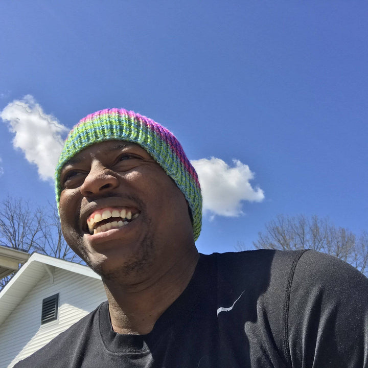 Pattern designer wearing #Boss Beanie while smiling with blue sky in the background.