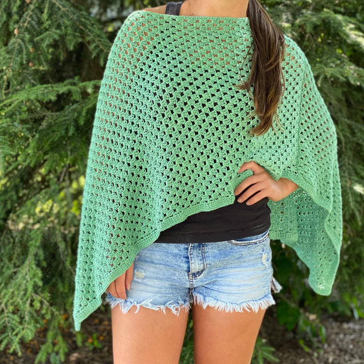 womens standing outside wearing a green poncho