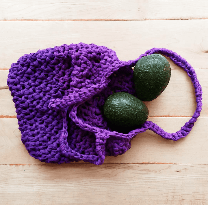 Violet Summer Tote Crochet bag on a wooden surface with 2 avocados