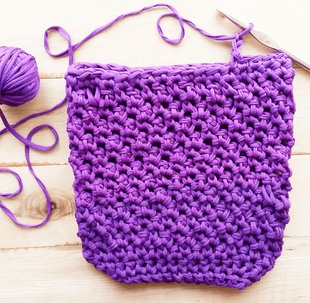 Partially made Violet Summer Tote Crochet Kit on a wooden background