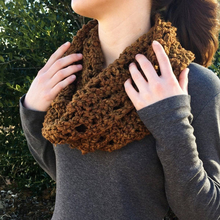 close up of a woman holding a brown shawl