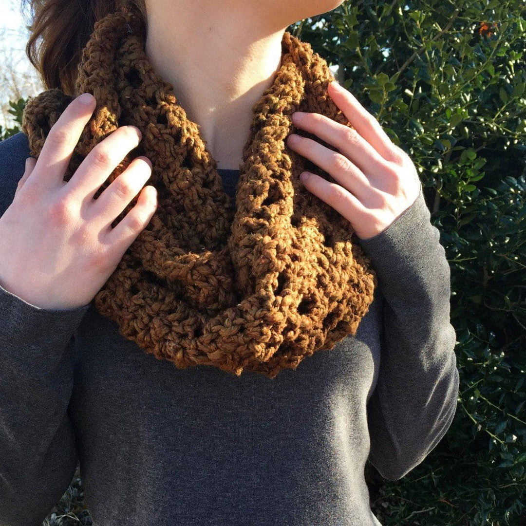 close up of a woman holding a brown shawl